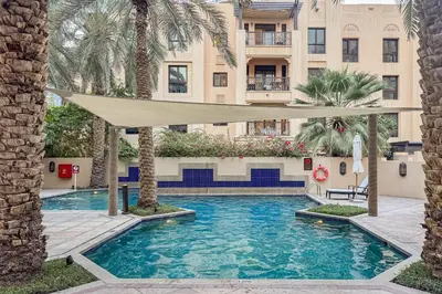 a swimming pool in the middle of a building with palm trees at Contemporary one-bedroom apartment in Burj Khalifa area by Norbu Holiday Homes in Dubai
