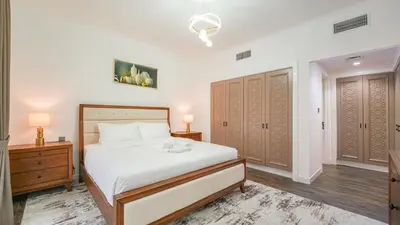 a bedroom with a bed and two night stands and two cabinets at Contemporary one-bedroom apartment in Burj Khalifa area by Norbu Holiday Homes in Dubai