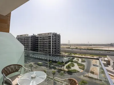a balcony with a table and a view of a city at The Comfort Cove Studio in Azizi Riviera 32 in Dubai