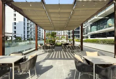 a patio with tables and chairs on a building at The Comfort Cove Studio in Azizi Riviera 32 in Dubai