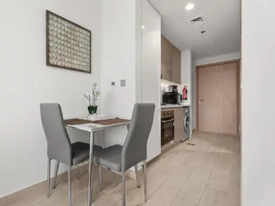 a kitchen with a table and chairs in a room at The Comfort Cove Studio in Azizi Riviera 32 in Dubai