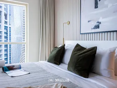 a bedroom with a bed with pillows and a window at Sea View 2BR in Dubai Marina near Dubai Eye in Dubai