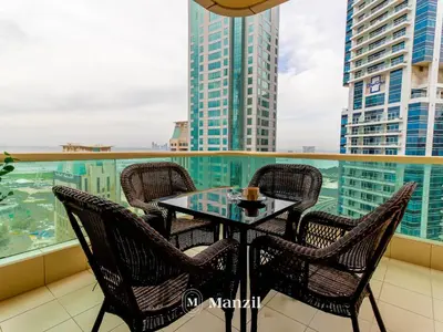 a table and chairs on the balcony of a building at Sea View 2BR in Dubai Marina near Dubai Eye in Dubai
