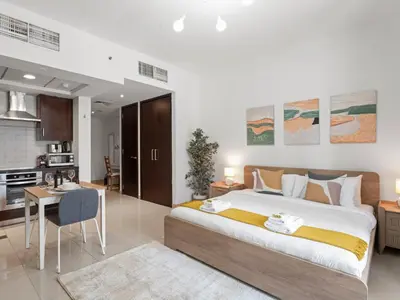 a bedroom with a large bed and a kitchen at The Havenette comfy Studio in 29 BLVD Walk in Dubai