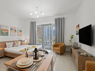 a living room with a bed and a dining room at The Havenette comfy Studio in 29 BLVD Walk in Dubai