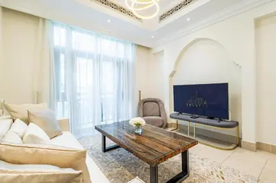 a living room with a couch and a table at Deluxe Arabian-Inspired One Bedroom Stay in Souk Al Bahar Downtown Dubai in Dubai