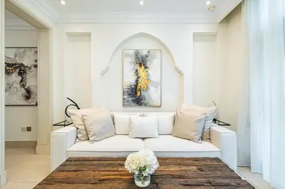 a living room with a white couch and a vase of flowers at Deluxe Arabian-Inspired One Bedroom Stay in Souk Al Bahar Downtown Dubai in Dubai