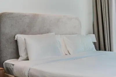 a bed with white sheets and pillows at TRPS - Trillionaire Residences, Business Bay - Private Jacuzzi, Modern 2BR Furnished, Canal View in Dubai