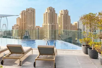 a balcony with two chairs and a view of a city at Bright & Modern 1BR in Dubai Marina in Dubai