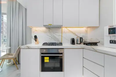 a kitchen with white cabinets and a stove at Bright & Modern 1BR in Dubai Marina in Dubai