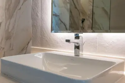 a white sink in a bathroom with a mirror at Bright & Modern 1BR in Dubai Marina in Dubai