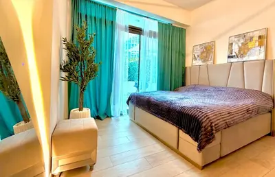 a bedroom with a bed and green curtains at Panoramic Apartment with Smart TV&Large Terrace in Dubai