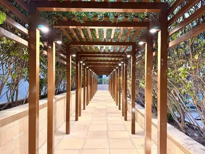 a wooden pergola with lights on a walkway at Panoramic Apartment with Smart TV&Large Terrace in Dubai