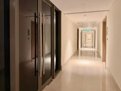 a corridor of a building with glass doors and a long hallway at Panoramic Apartment with Smart TV&Large Terrace in Dubai