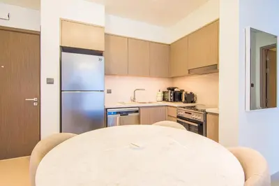 a kitchen with a table and a refrigerator at One Bedroom Apartment with Balcony in Act One Act Two, Downtown in Dubai