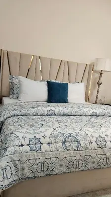 a large bed with blue and white sheets and pillows at ZAH Luxury Holiday Home at JBR,Dubai in Dubai