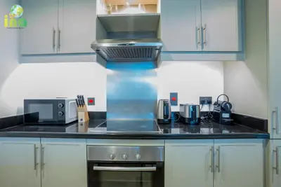 a kitchen with blue cabinets and a stove top oven at INA HOMES - Luxury 2 Bedroom Apartment with Full Burj Khalifa & Fountain Views in Dubai
