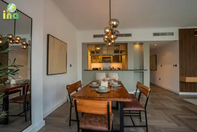 a dining room with a wooden table and chairs at INA HOMES - Luxury 2 Bedroom Apartment with Full Burj Khalifa & Fountain Views in Dubai