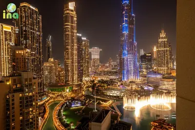a night view of a city with tall buildings at INA HOMES - Luxury 2 Bedroom Apartment with Full Burj Khalifa & Fountain Views in Dubai