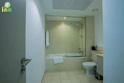a bathroom with a tub and a toilet and a sink at INA HOMES - Luxury 2 Bedroom Apartment with Full Burj Khalifa & Fountain Views in Dubai