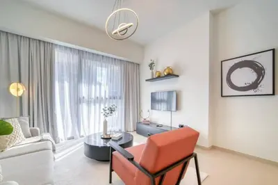 a living room with a red chair and a table at Oshima Act Two Downtown 1BR Burj Khalifa in Dubai