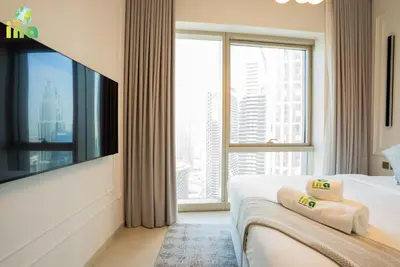 a hotel room with a large window and a bed at INA HOMES - Modren 2 Bedroom Apartment with Full Burj Khalifa View in Dubai