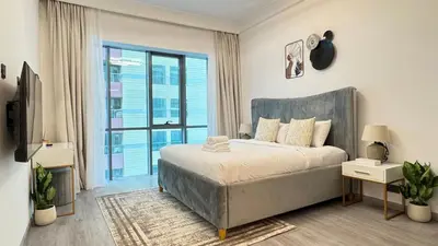 a bedroom with a bed and a large window at Studio in central location near the Metro in Dubai