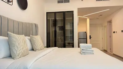 a white bed with two towels on top of it at Studio in central location near the Metro in Dubai