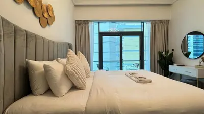 a bedroom with a large white bed with a mirror at Studio in central location with Balcony nearby Metro in Dubai