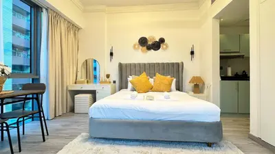 a bedroom with a large bed with yellow pillows at Studio centrally located with a huge private balcony in Dubai