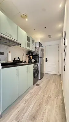 a kitchen with white cabinets and a washer and dryer at Studio centrally located with a huge private balcony in Dubai