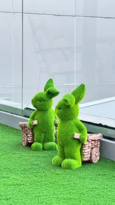 two green stuffed rabbits sitting in baskets on the grass at Studio centrally located with a huge private balcony in Dubai