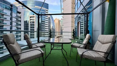 a balcony with a table and chairs and a view of a city at Studio centrally located with a huge private balcony in Dubai
