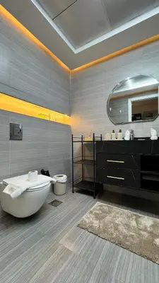 a bathroom with a tub and a toilet and a mirror at Studio centrally located with a huge private balcony in Dubai
