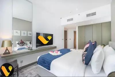 a bedroom with a large white bed and a tv at Vogue Business Bay Damac Maison Prive near Burj Khalifa and Dubai Mall, Studio Apartment with Balcony, Pool and City View, Access to all Amenities in Dubai