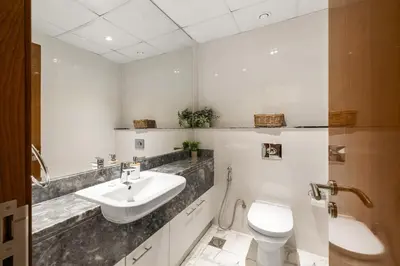 a white bathroom with a sink and a toilet at Stunning 1BR at Noora Tower, Al Habtoor City in Dubai