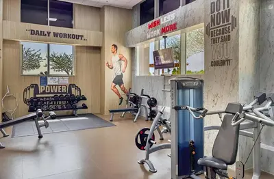 a gym with two treadmills and a man on a treadmill at Stunning 1BR at Noora Tower, Al Habtoor City in Dubai