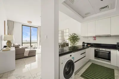 a kitchen and living room with a washer and dryer at Stunning 1BR at Noora Tower, Al Habtoor City in Dubai