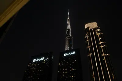 two tall skyscrapers with the burj khalifa at night at Werova - Luxury 2BR Apartment w Breathtaking View in Dubai