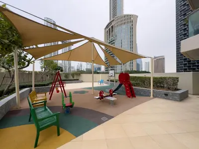 a playground with chairs and a swing in a city at Werova - Luxury 2BR Apartment w Breathtaking View in Dubai