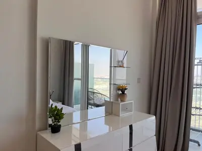 a white dressing table with a large mirror in a room at Modern 1BR Apartment Golf View Gym Pool in Dubai