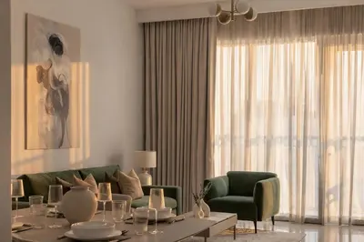 a living room with a couch and a table and chairs at 30th Floor Creek Harbour 1 Bedroom Apartment in Dubai