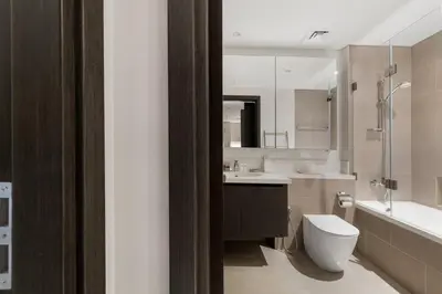 a bathroom with a toilet and a sink and a tub at 30th Floor Creek Harbour 1 Bedroom Apartment in Dubai