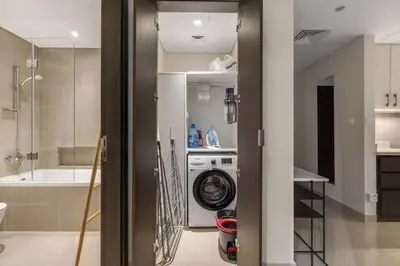a bathroom with a shower and a washing machine at 30th Floor Creek Harbour 1 Bedroom Apartment in Dubai