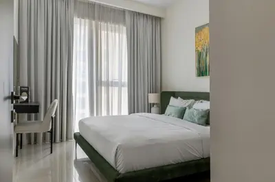 a bedroom with a bed and a desk and a window at 30th Floor Creek Harbour 1 Bedroom Apartment in Dubai