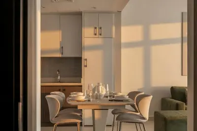 a dining room with a table and chairs and a kitchen at 30th Floor Creek Harbour 1 Bedroom Apartment in Dubai