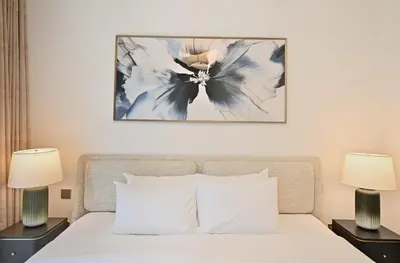 a bedroom with a white bed with two lamps at Grand Bleu by Elie Saab Residency, Private Beach - Dubai Harbour - 2BR in Dubai
