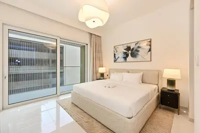 a bedroom with a large bed and a large window at Grand Bleu by Elie Saab Residency, Private Beach - Dubai Harbour - 2BR in Dubai