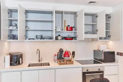 a kitchen with white cabinets and a counter top at PS5- Designer 2BR with Private Beach, Dubai Eye, Palm in Dubai