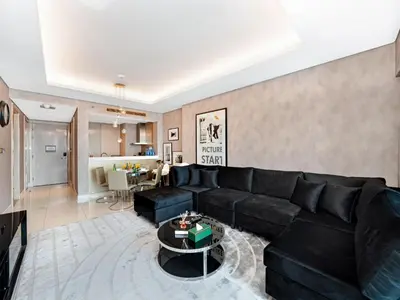 a living room with a black couch and a table at Sky-high 1Br Apartment Sleeps 4 in Damac Paramount in Dubai